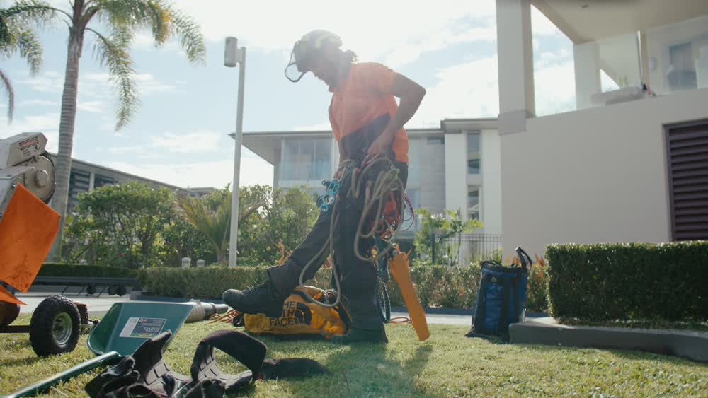 Arborist organizing tools next to a wood chipper